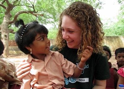 Volontaria si prende cura di un'alunna per il progetto di missioni umanitarie a New Delhi Una volontaria in missione umanitaria in India accudisce una bambina
