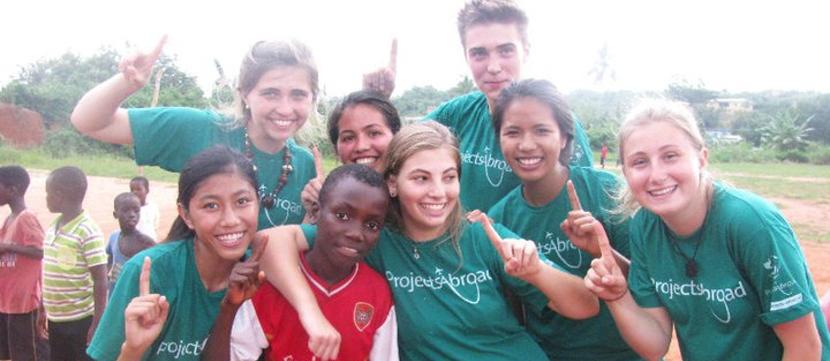 Una volontaria di Porjects Abroad con un gruppo di bambini che partecipano al progetto sport Un gruppo di bambini e una volontaria del progetto di sport comunitario di Projects Abroad