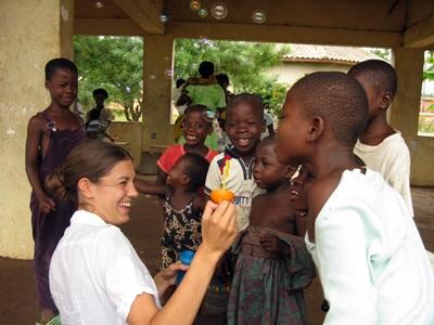 Ghana, volontaria e bambini giocano con bolle di sapone Volontaria gioca con i bambini in Ghana